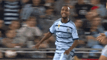 a soccer player wearing a jersey that says adidas on the front