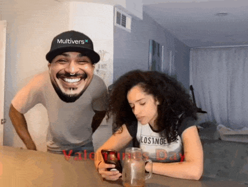 a man wearing a hat that says multivers laughs while a woman looks at her phone