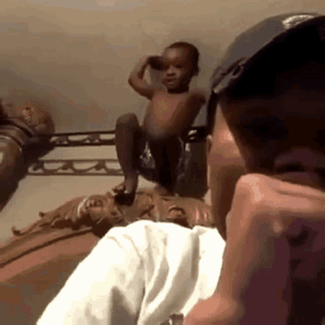 a man is talking on a cell phone while a little boy sits on his lap