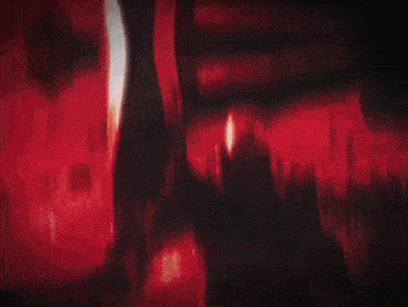 a man with a bloody face is holding a sword in front of a crowd