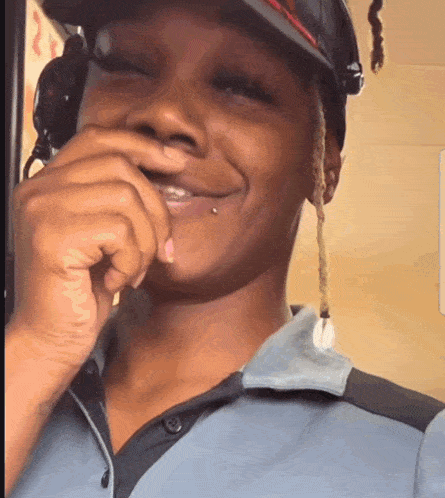 a woman wearing headphones and a hat is smiling