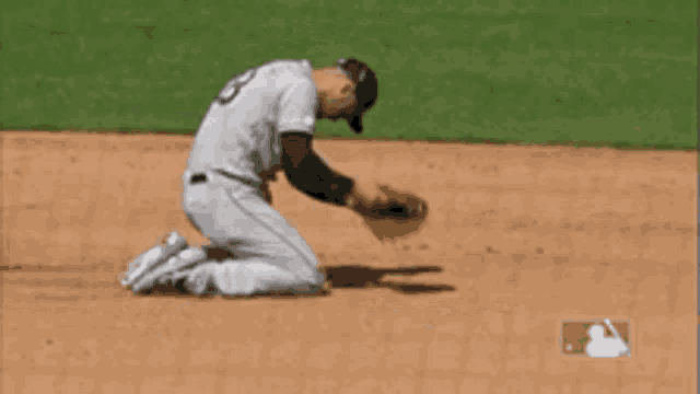 a baseball player kneeling on the field with a mlb logo in the corner