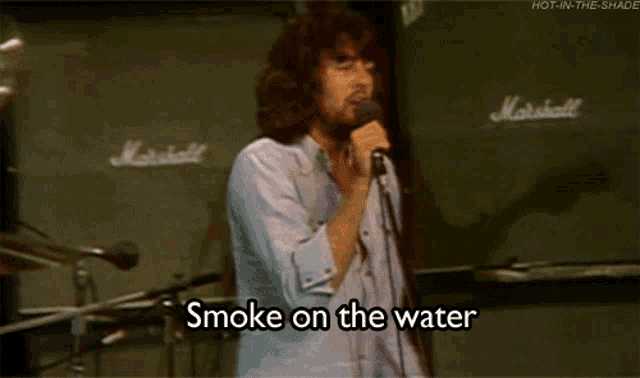 a man singing into a microphone with the words smoke on the water written below him