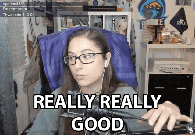 a woman sitting in front of a microphone with the words " really really good " above her