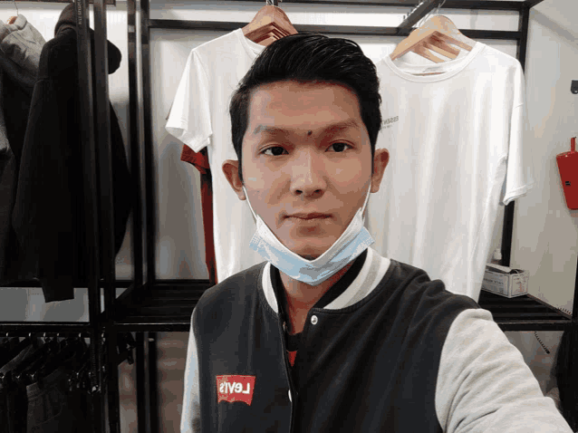 a man wearing a face mask and a levi 's jacket takes a selfie