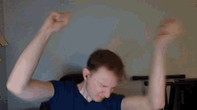 a man in a blue shirt is making a funny face