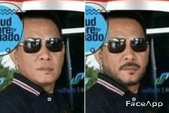 a man with sunglasses and a beard is standing in front of a bus .