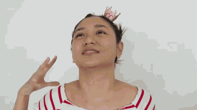 a woman in a red and white striped shirt is smiling and clapping .