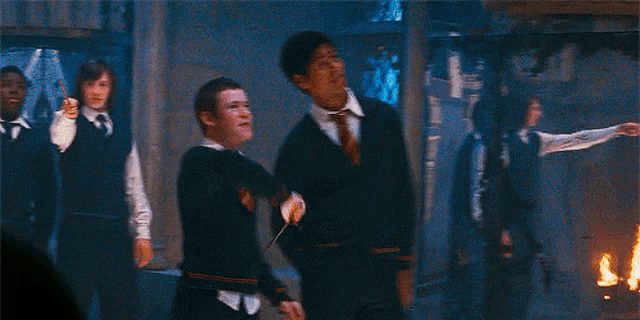 a group of people are standing in a dark room and one of them is holding a sword in his mouth .