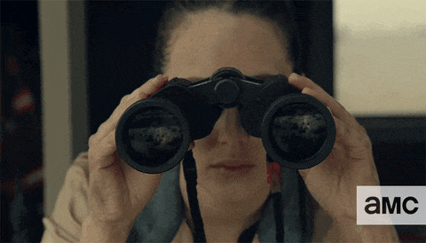 a woman is looking through binoculars with the letters amc visible in the corner
