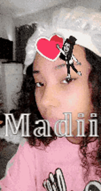 a girl wearing a hat with a heart on it and the name madii