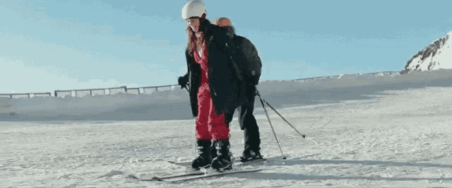 two people are skiing down a snow covered slope