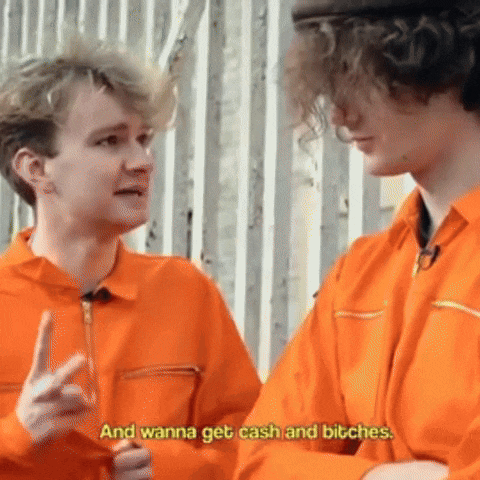 two men in orange jumpsuits are standing next to each other and talking .