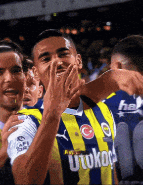 a soccer player wearing a yellow and blue uniform with the word utokop on it