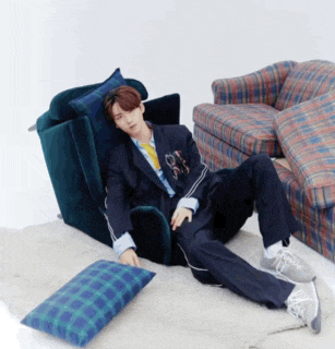 a man in a suit is laying on the floor next to a couch and chair