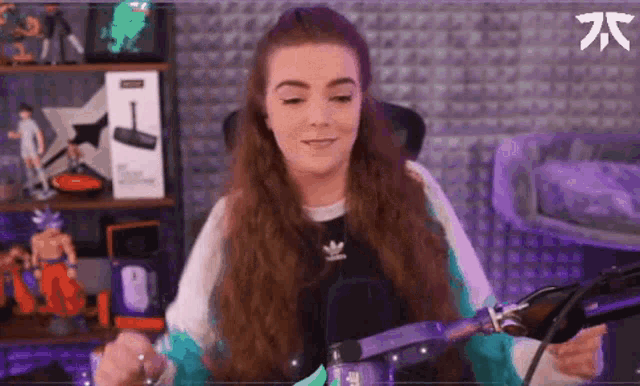 a woman with long hair is sitting in front of a microphone in a room with a purple wall .
