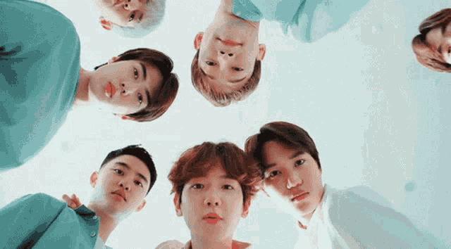 a group of young men are looking down at the camera
