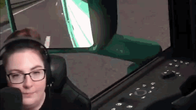 a woman wearing glasses and headphones is sitting in a car