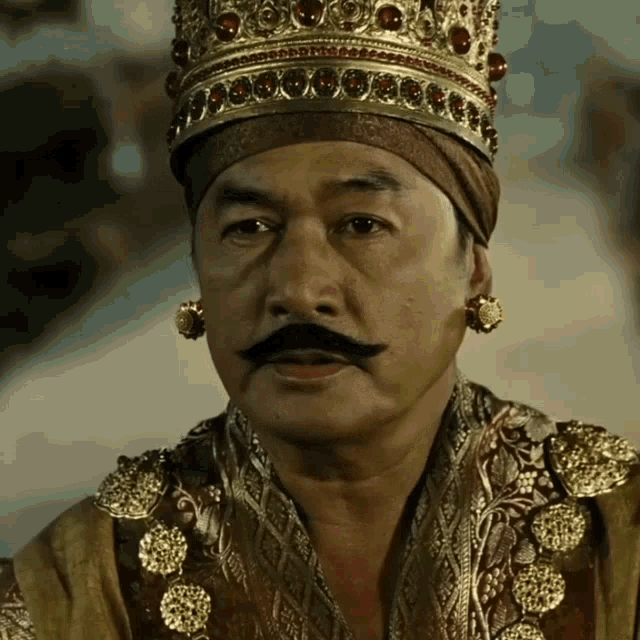 a man with a mustache and a crown on his head looks serious