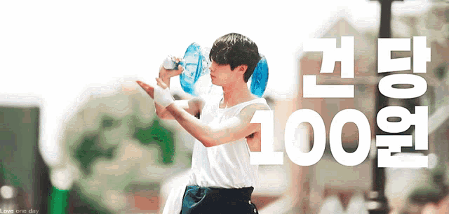 a man drinking from a water bottle with the number 100 in white letters