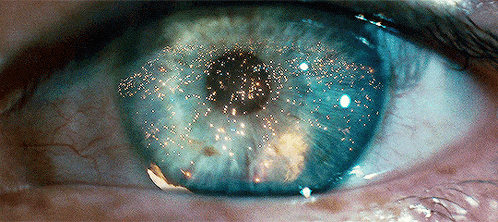 a close up of a person 's eye with a reflection of a fireworks display