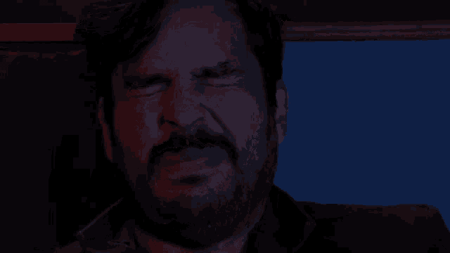 a man with a beard says done in front of a blue background