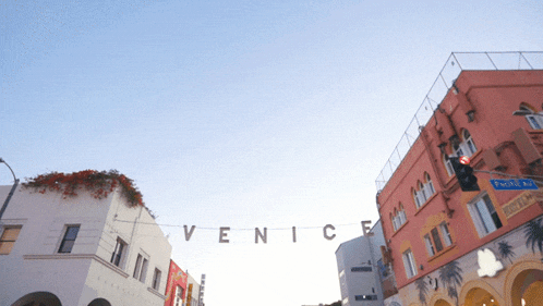 a sign that says venice hangs from a street light