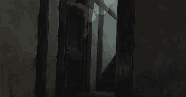 a dark hallway with a shadow of a person on the wall