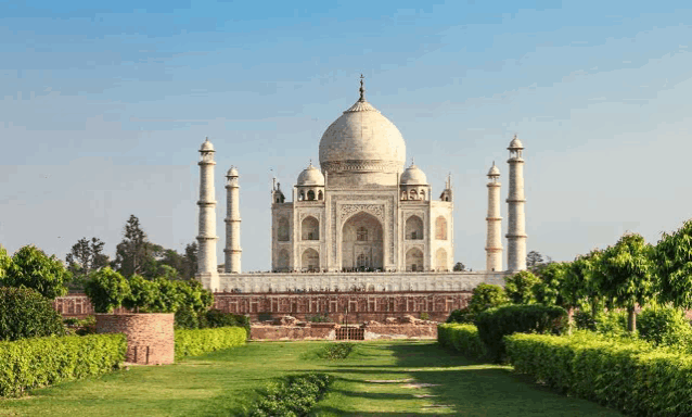 the taj mahal is surrounded by a lush green park