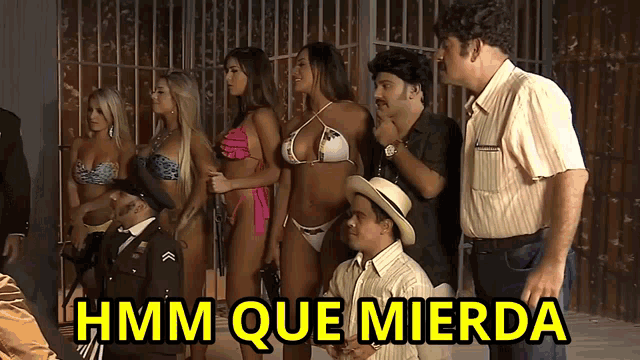 a group of people standing in front of a sign that says hmm que mierda on it