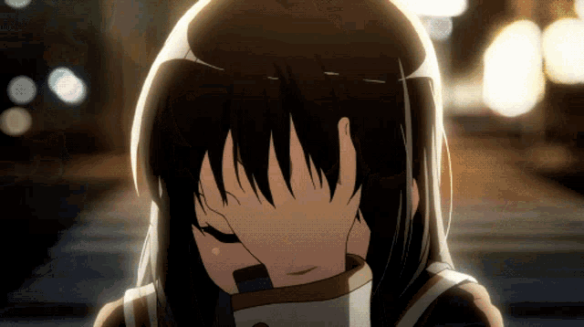 a girl with long black hair covering her face with her hand