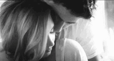 a black and white photo of a man and woman hugging and kissing .