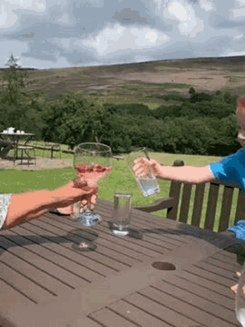 a woman and a child are sitting at a table holding glasses of water .