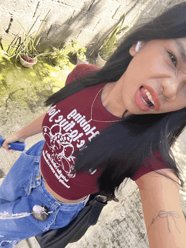 a woman wearing a maroon shirt that says primitive witches