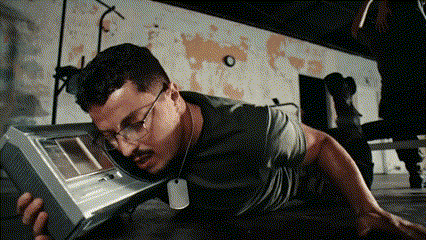 a man wearing glasses and a dog tag is holding a device