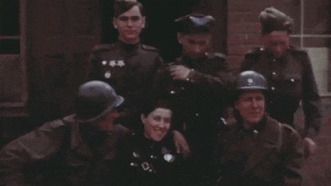 a group of soldiers posing for a picture with one wearing a helmet that has the letter d on it