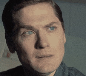 a man with blue eyes is looking at the camera