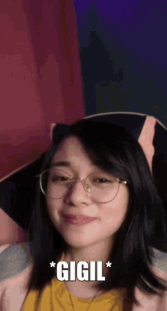 a girl wearing glasses and a pink hat says gigil *