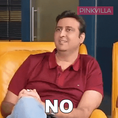 a man in a red shirt is sitting on a yellow couch and saying " no "