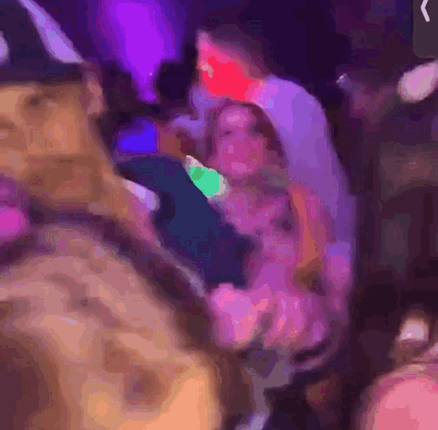 a blurry picture of a group of people dancing in a club