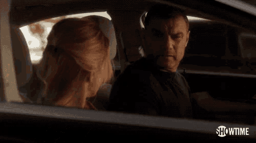 a man and woman are sitting in a car with showtime written on the bottom right