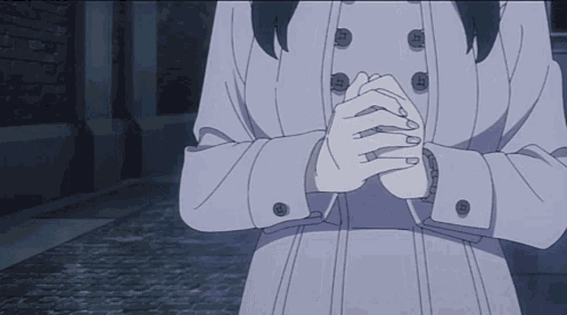 a woman in a white coat has her hands folded in front of her face