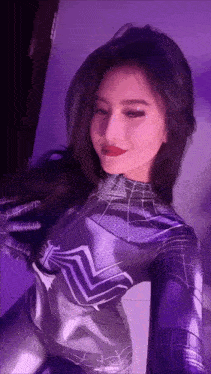 a woman in a spiderman costume poses for a picture