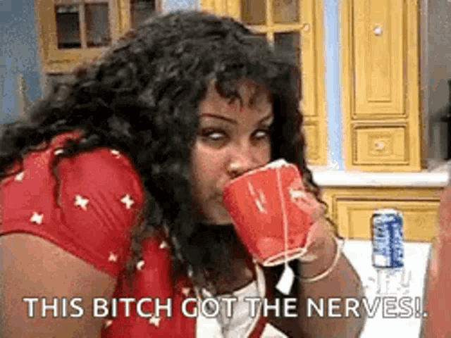 a woman is drinking from a red cup and says `` this bitch got the nerves ! ''