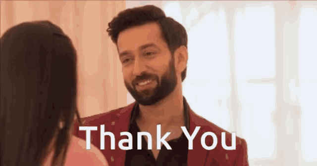 a man in a red jacket is standing next to a woman and says thank you