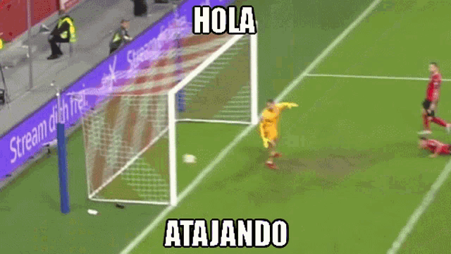 a soccer goalie leaps to catch a ball with the words hola atajando above him
