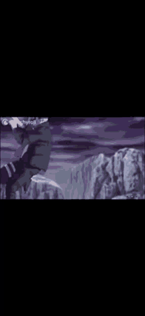 a man is standing on top of a mountain with a purple background .