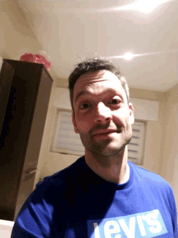 a man wearing a blue shirt that says levis