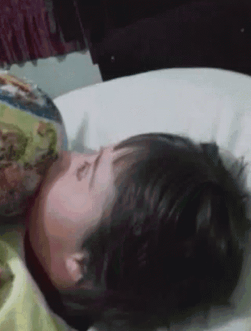 a young boy is sleeping on a bed with a blanket that says ' disney ' on it