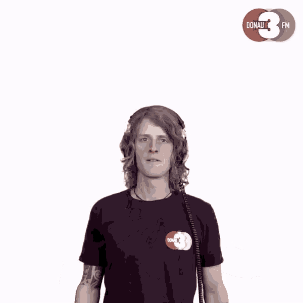 a man wearing headphones is dancing in front of a donau fm logo
